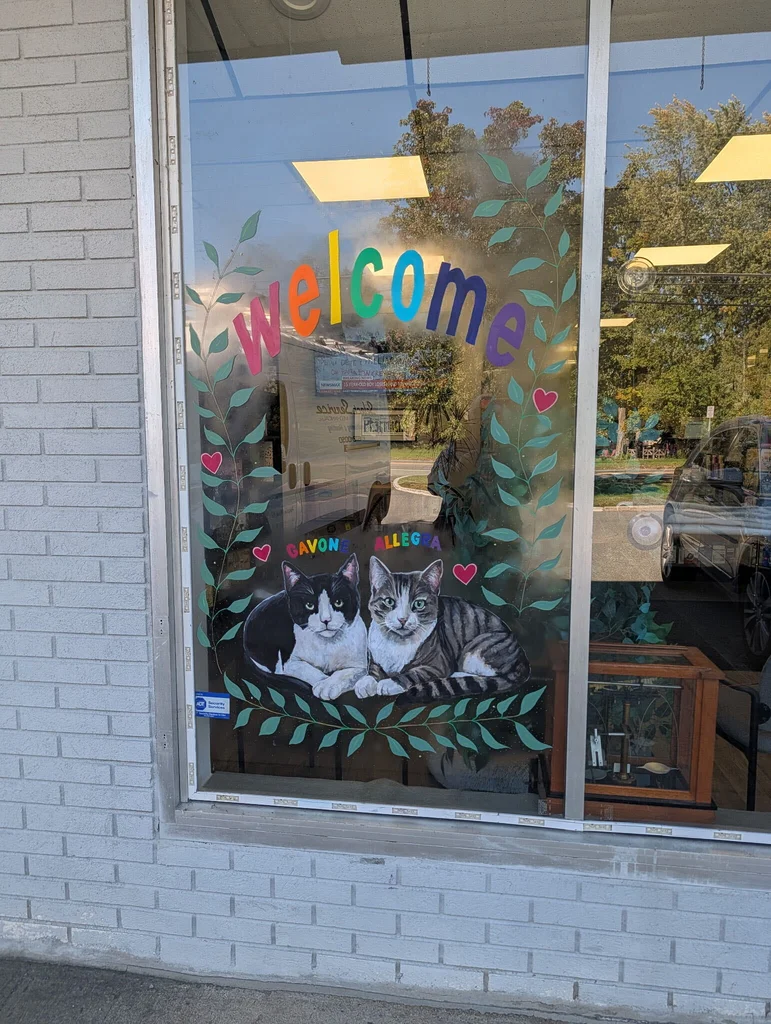Rockaway Pharmacy window mural with Welcome lettering and portraits of Gavone and Allegra